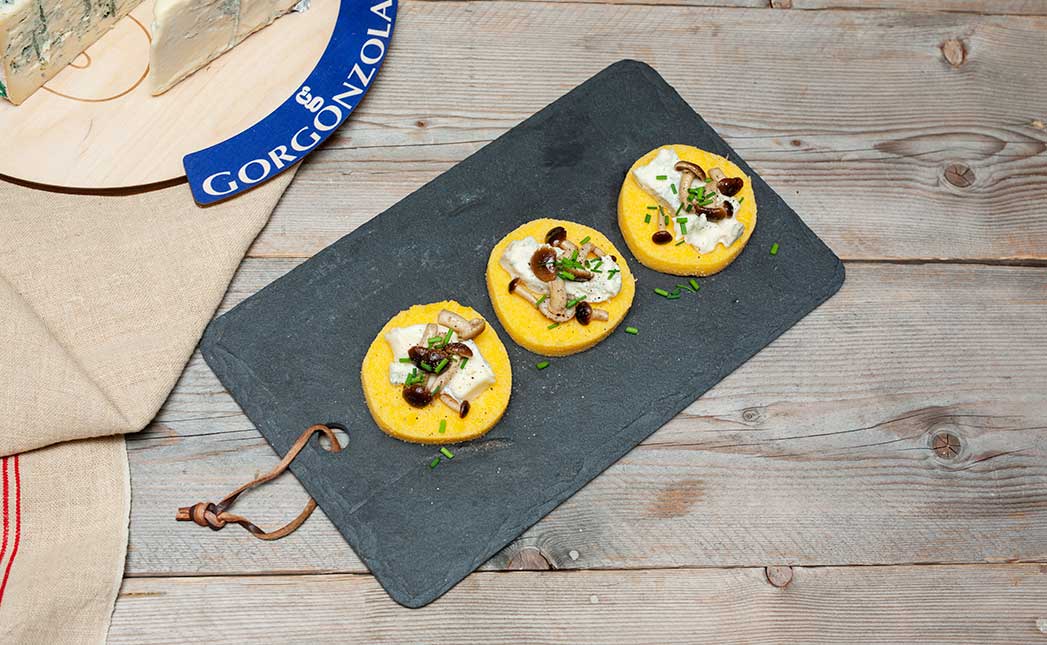 Polenta canapes with sweet Gorgonzola, sautéed mushrooms and chives - Gorgonzola DOP
